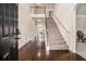 Elegant foyer features hardwood floors, a staircase with iron spindles, and wainscoting adding a touch of sophistication at 640 Parkside Place Dr, Mcdonough, GA 30253