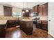 A kitchen with hardwood floors, granite counters, island, stainless steel appliances, and dark wood cabinets at 640 Parkside Place Dr, Mcdonough, GA 30253