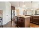 A kitchen with hardwood floors, stainless steel refrigerator, granite counters, island, and dark wood cabinets at 640 Parkside Place Dr, Mcdonough, GA 30253