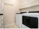 A laundry room with a washer and dryer, storage racks, and neutral paint at 640 Parkside Place Dr, Mcdonough, GA 30253