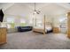 Spacious main bedroom with a four poster bed, ceiling fan, and natural light at 640 Parkside Place Dr, Mcdonough, GA 30253