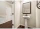 A powder room with hardwood floors, white trim, and a pedestal sink at 640 Parkside Place Dr, Mcdonough, GA 30253