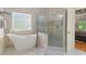 Luxurious bathroom features freestanding tub, glass enclosed shower, and stained glass window at 519 River Estates Pkwy, Canton, GA 30115
