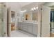 Bright bathroom features a double vanity, large mirror, and shower with glass door at 519 River Estates Pkwy, Canton, GA 30115