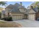 Home with a three-car garage and combination of stone and wood siding at 519 River Estates Pkwy, Canton, GA 30115