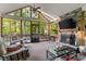 Inviting sunroom with stone fireplace, beamed ceiling, and floor-to-ceiling windows overlooking the yard at 519 River Estates Pkwy, Canton, GA 30115