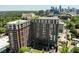 Aerial view showcasing the building's architectural design, its balconies, parking area and the surrounding cityscape at 1820 Peachtree Nw St # 1008, Atlanta, GA 30309