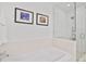 Bathroom featuring a bathtub with a glass shower door and tiled walls at 1820 Peachtree Nw St # 1008, Atlanta, GA 30309