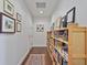 Inviting hallway featuring a wood bookshelf lined with books, hardwood floors, and curated artwork at 1820 Peachtree Nw St # 1008, Atlanta, GA 30309