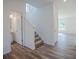 Bright foyer with wood-look flooring, staircase, and adjacent powder room at 2117 Boxwood Se Cir, Conyers, GA 30094