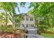 Back exterior of a house with wooden deck surrounded by mature trees and landscaping at 3902 Concord Walk Se Dr, Smyrna, GA 30082