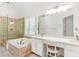 Modern bathroom featuring a soaking tub, glass shower, double sink vanity, and plantation shutters at 3902 Concord Walk Se Dr, Smyrna, GA 30082