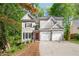 Inviting home featuring a red front door, black shutters, a two-car garage, and landscaped front yard at 3902 Concord Walk Se Dr, Smyrna, GA 30082