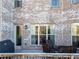 Inviting back porch with brick exterior, outdoor seating, and door for easy access at 12640 Hearthstone Way, Alpharetta, GA 30009