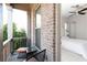 Inviting outdoor balcony featuring a seating area, brick surround, and view of trees at 12640 Hearthstone Way, Alpharetta, GA 30009