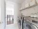 Efficient laundry room equipped with modern appliances and ample storage space with shelving at 12640 Hearthstone Way, Alpharetta, GA 30009