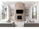 Stylish living room featuring a stone fireplace, built-in shelves, and lots of natural light at 12640 Hearthstone Way, Alpharetta, GA 30009