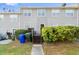 The back exterior of the townhome with stairs leading to the deck, a small lawn, and green shrubbery at 241 Odyssey Turn Nw, Conyers, GA 30012