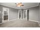 Carpeted bedroom features neutral walls with white trim and access to bathroom and closets at 241 Odyssey Turn Nw, Conyers, GA 30012
