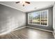 This bedroom has hardwood flooring and a large window at 241 Odyssey Turn Nw, Conyers, GA 30012