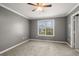 Bedroom with natural light offers plush carpeting, gray walls, and a ceiling fan at 241 Odyssey Turn Nw, Conyers, GA 30012