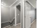 Hallway with gray walls leads to an open door and stairs, featuring neutral carpet at 241 Odyssey Turn Nw, Conyers, GA 30012