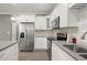 Modern kitchen with stainless steel appliances, white cabinetry, and a view of the dining area at 241 Odyssey Turn Nw, Conyers, GA 30012