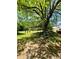 Spacious backyard featuring mature tree, covered metal shelter, and well-maintained lawn at 5700 Abbotts Bridge Rd, Johns Creek, GA 30097
