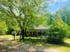Tranquil backyard featuring home's screened porch, expansive green space, and mature trees at 5700 Abbotts Bridge Rd, Johns Creek, GA 30097