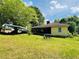 Exterior view of home with large yard, carport, and screened porch at 5700 Abbotts Bridge Rd, Johns Creek, GA 30097