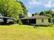 Exterior view of home with large yard, carport, and screened porch at 5700 Abbotts Bridge Rd, Johns Creek, GA 30097