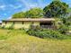 Home exterior with back porch surrounded by overgrown foliage and green space at 5700 Abbotts Bridge Rd, Johns Creek, GA 30097