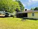 Exterior view of home with large yard, carport, and screened porch at 5700 Abbotts Bridge Rd, Johns Creek, GA 30097