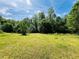 Beautiful lot surrounded by mature trees on a bright, sunny day at 5700 Abbotts Bridge Rd, Johns Creek, GA 30097