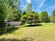 Expansive yard featuring a small outbuilding and a mature shade tree at 5700 Abbotts Bridge Rd, Johns Creek, GA 30097