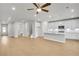 Open living area with hardwood floors that connects to a bright kitchen with white cabinets at 5761 Tillman Way, Powder Springs, GA 30127