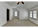 A bright bedroom with neutral carpet, large windows, and a modern ceiling fan at 7160 Round Rd, Cumming, GA 30040