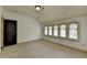Bedroom with large windows bringing in light and a dark-stained door at 7160 Round Rd, Cumming, GA 30040