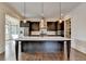An open concept kitchen with an island, white marble countertops and stainless steel appliances at 7160 Round Rd, Cumming, GA 30040