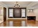 Living room with hardwood floors, black accent wall, and an open door to the bathroom at 7160 Round Rd, Cumming, GA 30040