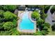 Aerial view of a community pool with lounge chairs, umbrellas, trees and nearby parking at 7160 Round Rd, Cumming, GA 30040