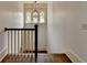 Classic staircase with wood railing, decorative lighting, and neutral walls at 7160 Round Rd, Cumming, GA 30040
