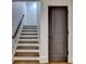 Stairway with painted steps, wood treads, and a modern door at 7160 Round Rd, Cumming, GA 30040