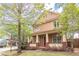 Attractive two-story home with a inviting front porch, flowers and a beautiful tree at 9912 Mancunian Way, Douglasville, GA 30135