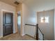 Second floor hallway featuring a carpeted floor, a view into a bedroom and a stairwell at 9912 Mancunian Way, Douglasville, GA 30135