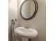 Clean powder room featuring a pedestal sink, mirror and towel rack at 9912 Mancunian Way, Douglasville, GA 30135