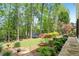 Expansive backyard with mature trees, landscaped gardens, and outdoor play area at 1228 Dunwoody Walk, Atlanta, GA 30338