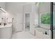 Bright bathroom with garden tub, open doorway, and large window with natural light at 1228 Dunwoody Walk, Atlanta, GA 30338