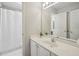 Bright bathroom featuring a vanity, large mirror, and a view into a shower and another room at 1228 Dunwoody Walk, Atlanta, GA 30338