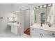 Bathroom showcasing double sinks, bright lighting, and an open doorway to another room at 1228 Dunwoody Walk, Atlanta, GA 30338